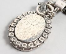 A VICTORIAN ENGRAVED OVAL SILVER LOCKET AND CHAIN.