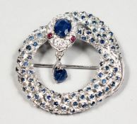 A SILVER SAPPHIRE AND RUBY EYE SNAKE BROOCH.
