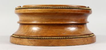 AN ERLY 20TH CENTURY TURNED WALNUT STAND, with two rows of brass beadwork mounts. Base diameter 10.