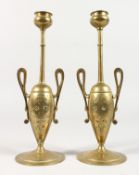 A PAIR OF CLASSICAL GREEK STYLE TWO HANDLED BRASS URN SHAPED CANDLESTICKS. 6.5ins high.