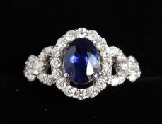 A SUPERB 18CT WHITE GOLD OVAL SAPPHIRE 1.18CTS, surrounded by small diamonds.