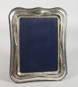 A SILVER PHOTOGRPH FRAME with shaped border. 9.5ins x 7ins.