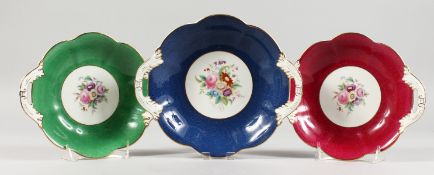 THREE FLORAL DECORATED COALPORT TWIN HANDLED PORCELAIN DISHES. One 9ins wide, two 8.5ins wide.