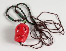 A SKULL CARVED CORAL PENDANT.