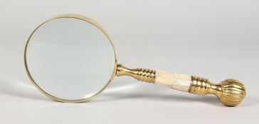 A LARGE MAGNIFYING GLASS with brass and mother-of-pearl handle.