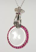 A SILVER MAGNIFYING GLASS PENDANT on a chain.