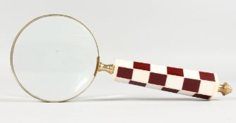 A MAGNIFYING GLASS with checked handle.