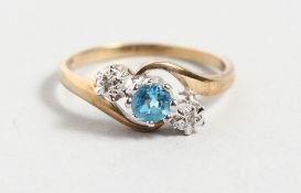 A 9CT YELLOW GOLD, DIAMOND AND BLUE STONE CROSSOVER RING.