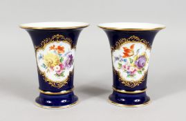 A GOOD PAIR OF MEISSEN PORCELAIN BLUE GROUND TRUMPET VASES, edged in gilt and painted with a panel