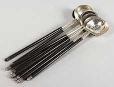 A SET OF EIGHT CHINESE SILVER LADLES with wooden handles.