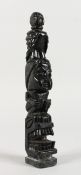 A MINIATURE CARVED STONE TOTEM POLE. 8ins high.