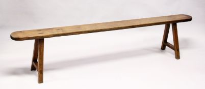 A 19TH CENTURY ELM TRESTLE BENCH, single plank construction, rounded ends on stretchered square