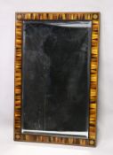 A REGENCY DESIGN RECTANGULAR MIRROR, with specimen wood sectional frame, the corners with an