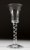 A GEORGIAN WINE GLASS with inverted plain bell shaped bowl and air twist stem. 6ins high.