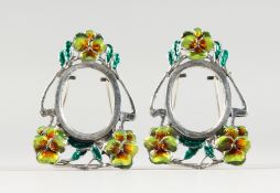 A PAIR OF MINIATURE ART NOUVEAU STYLE SILVER AND ENAMEL PHOTOGRAPH FRAMES. 1.75ins high.