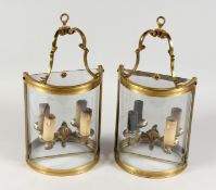 A PAIR OF BRASS AND GLASS BOWFRONT TWIN BRANCH ELECTRIC WALL LIGHTS. 15ins high x 8ins wide.