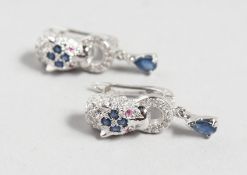 A GOOD PAIR OF SILVER PANTHER DESIGN SAPPHIRE SET EARRINGS.