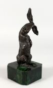 A SMALL ABSTRACT BRONZE OF A HARE, mounted on a marble base. 8.5ins high.