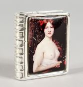 A SILVER BOOK SHAPED PILL BOX, the lid with an enamel semi-nude. 1.5ins diameter.
