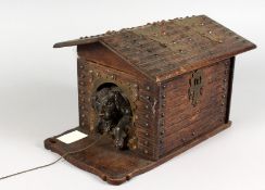 A VERY GOOD BLACK FOREST CARVED WOOD DOG IN A KENNEL SMOKING COMPACTUM, the roof of the dog kennel
