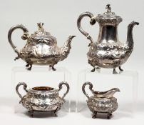 A GOOD VICTORIAN SILVER FOUR PIECE TEA SET with repousse decoration on claw feet, comprising teapot,