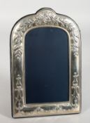 A SILVER PHOTOGRAPH FRAME, arched top repousse with flowers. 10ins x 6ins.