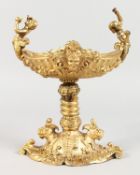 A SMALL GILT BRONZE CENTREPIECE TABLE SALT of classical design with cherub handles. 9ins high.