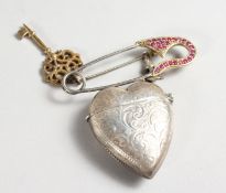A SILVER HEART SHAPED VESTA on a gold plated pin.