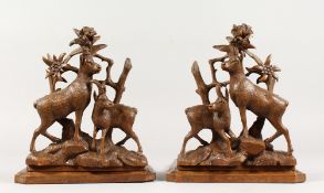 A GOOD PAIR OF BLACK FOREST CARVED WOOD DEER BOOKSTANDS. 11ins high.