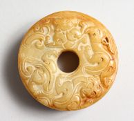 A CHINESE ARCHAIC STYLE CARVED ROUNDEL. 2.25ins diameter.