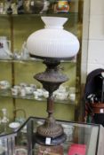 A Victorian copper oil lamp with opaque glass shade.
