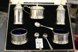 A cased silver five piece condiment set with spoons.