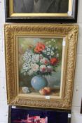 A still life of flowers in a vase with fruit, oil on canvas in a decorative gilt frame.