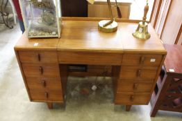 A Heal's walnut kneehole dressing table with lift-up mirror.