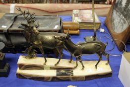 An Art Deco cast metal and alabaster group modelled as a stag and doe, on a plinth base.