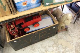 A trunk containing various wooden toys together with a push-along dog toy.
