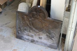 A 17th century style cast iron fire back decorated with a coat-of-arms.