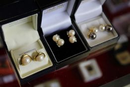 Three pairs of pearl earrings.
