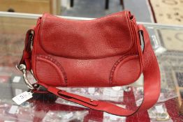 A Burberry of London red leather hand bag.