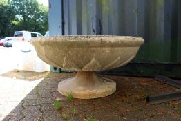 A large circular pedestal reconstituted stone garden urn.