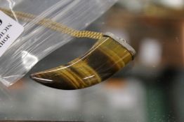 A tiger's eye tooth shaped pendant and chain.