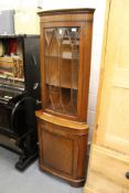 A mahogany standing corner cabinet.