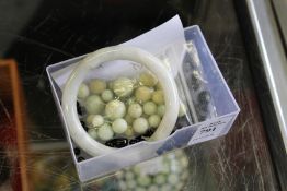 A jade bangle and similar beads.