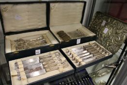 Two part cased sets of continental flatware together with an embossed metal tray.