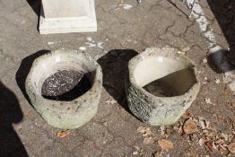 A pair of reconstituted stone garden pots.