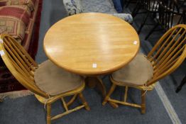 A small circular kitchen table and two chairs.