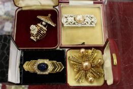 Four boxed brooches.