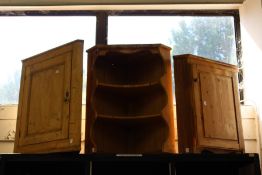 A pine corner cupboard and similar cupboard with shelves.