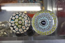 A commemorative glass paperweight,dated 1973, together with a similar paperweight.