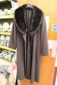 A ladies' full length coat with faux fur collar.